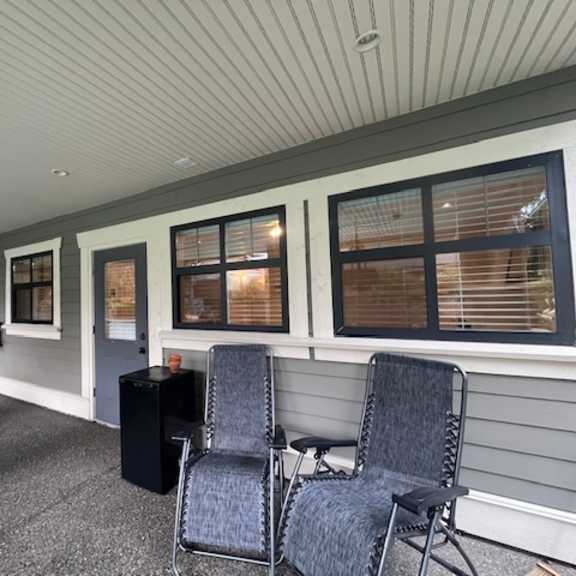 a patio with a black chair and a black cooler.