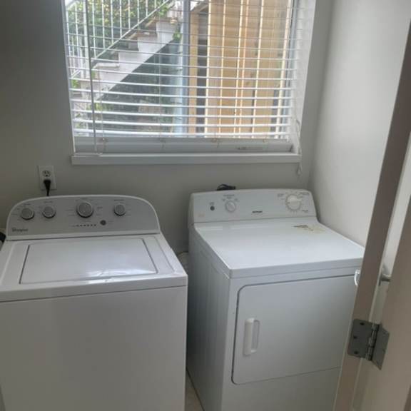 two white front loading washing machines in a laundry room.