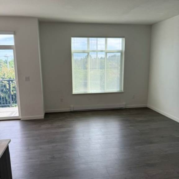 a room with a large window and wooden flooring.