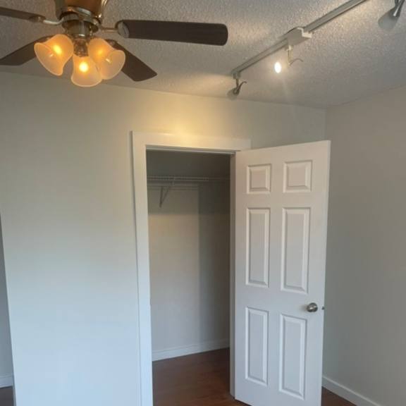 a room with a white door and a ceiling fan.