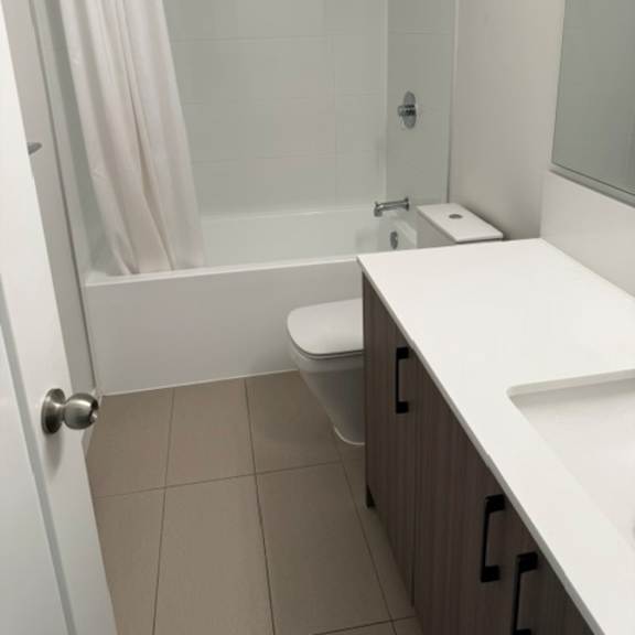 a white toilet sits in a bathroom next to a walk-in shower.