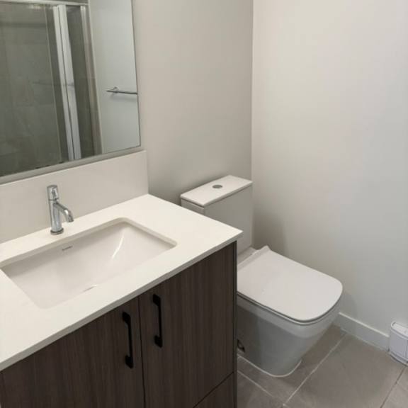 a white sink in a bathroom with a toilet in the corner.