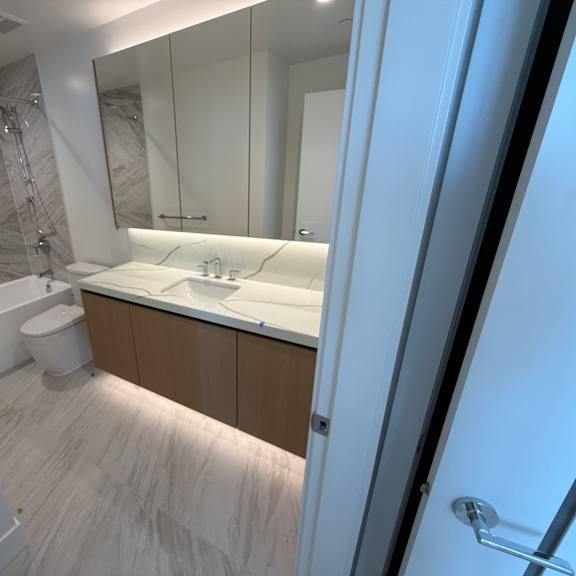 a bathroom with a toilet, sink, and mirror.