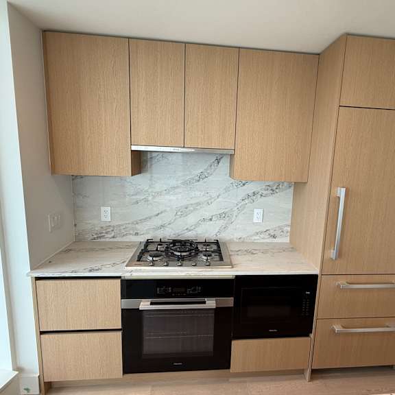 a kitchen with a marble countertop and wooden cabinets.