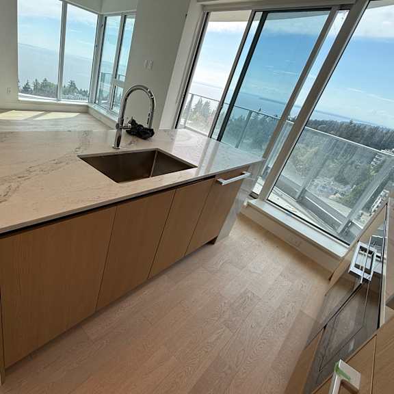 a modern kitchen with a large window overlooking the ocean.