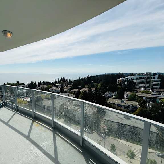 a balcony with a metal railing overlooking a cityscape.