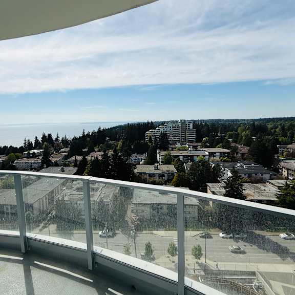a view from a balcony overlooking a parking lot and buildings.