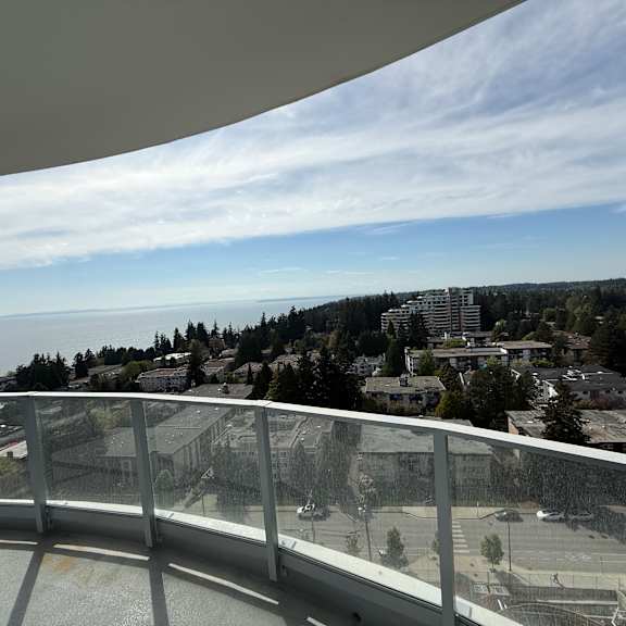 a balcony overlooks a parking lot and buildings.