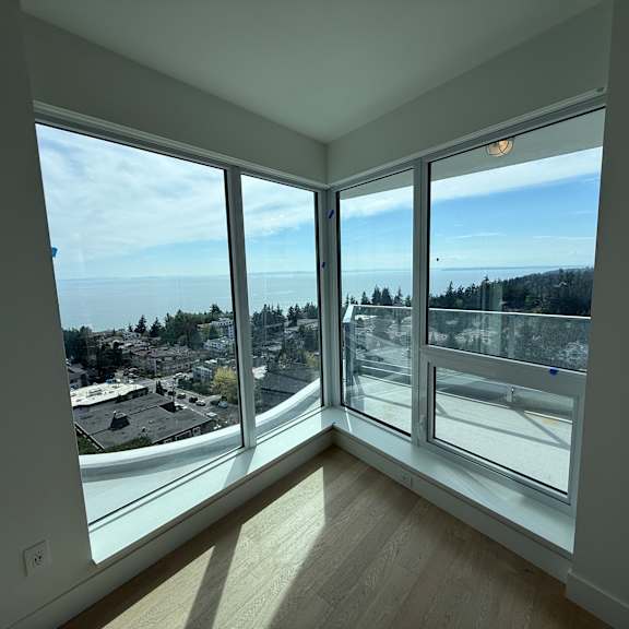 a room with a view of a parking lot and trees.