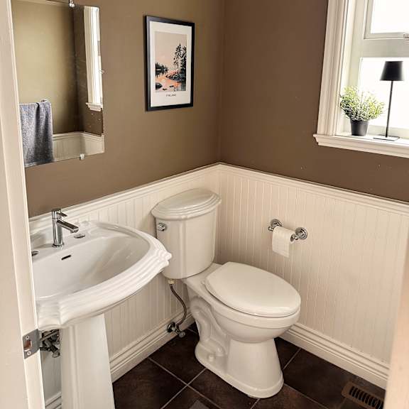a white toilet sits in a bathroom next to a sink.