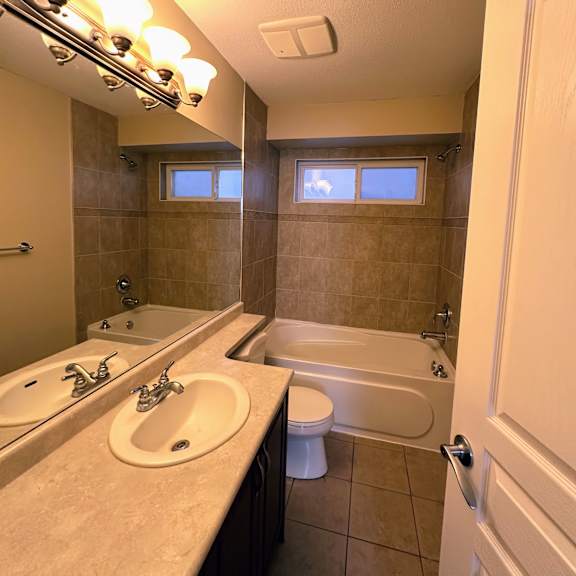 a bathroom with a tub, toilet, and sink.