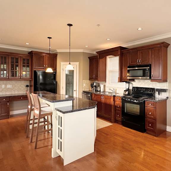 a kitchen with wooden floors and a quote on the wall.