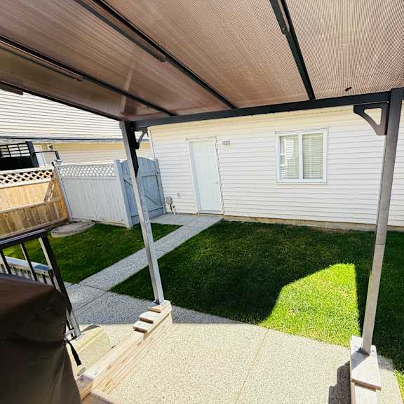 a patio with a white fence and a white house.