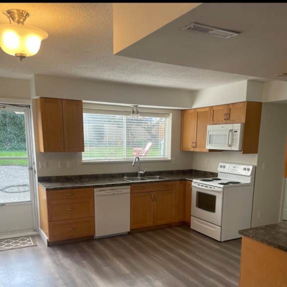 a kitchen with wooden cabinets and a white stove top oven.