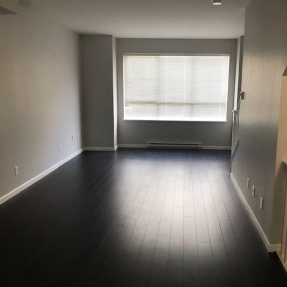 a room with a window and a wooden floor.