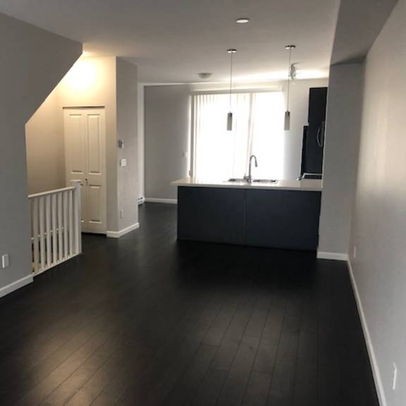 a spacious kitchen with a black countertop and a white door.