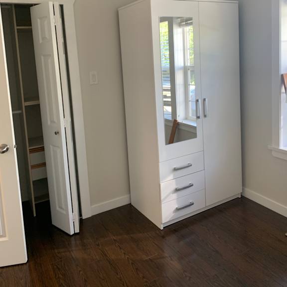 a white air conditioner unit is installed in a room with wooden walls.