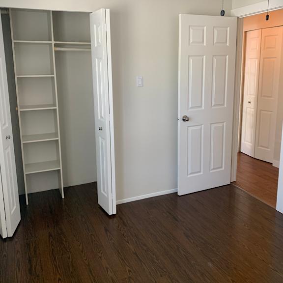 a white cabinet with five shelves is mounted on a wall.