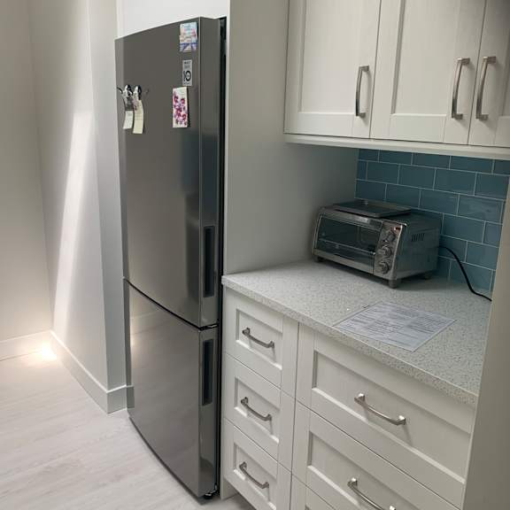 a kitchen with white cabinets and a stainless steel dishwasher.