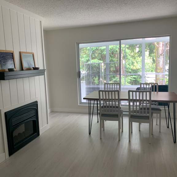 a room with a fireplace and a table with chairs.