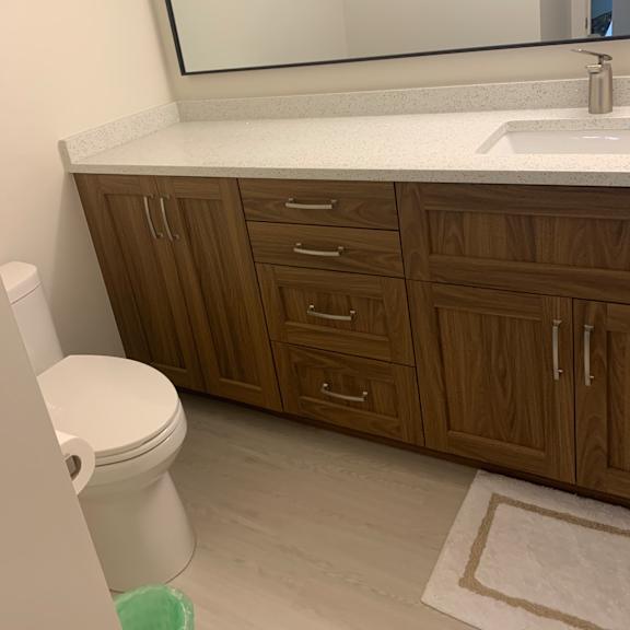 a white toilet sits in a bathroom next to a wooden cabinet.