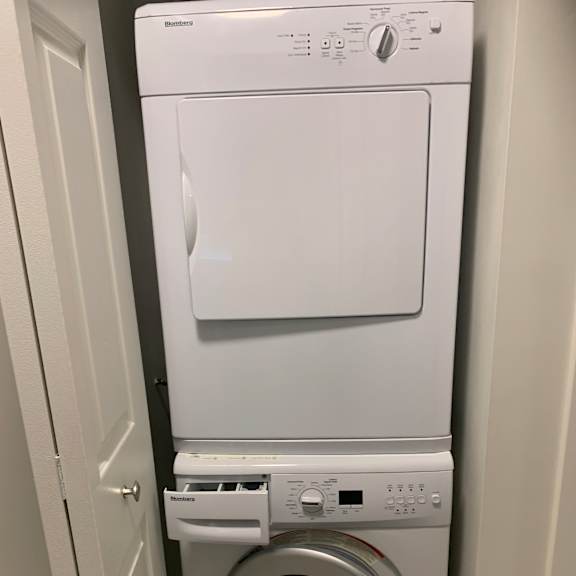 a white microwave oven with a white washing machine next to it.