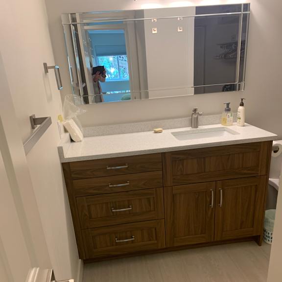 a bathroom with a brown cabinet and a white counter.