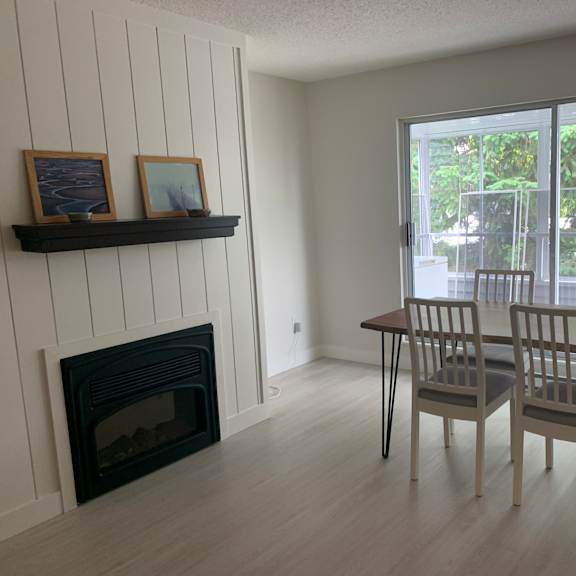 a room with a fireplace and a table with chairs.