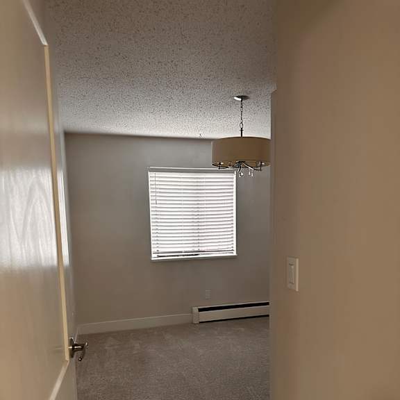 a room with a window and a wall-mounted shower head.