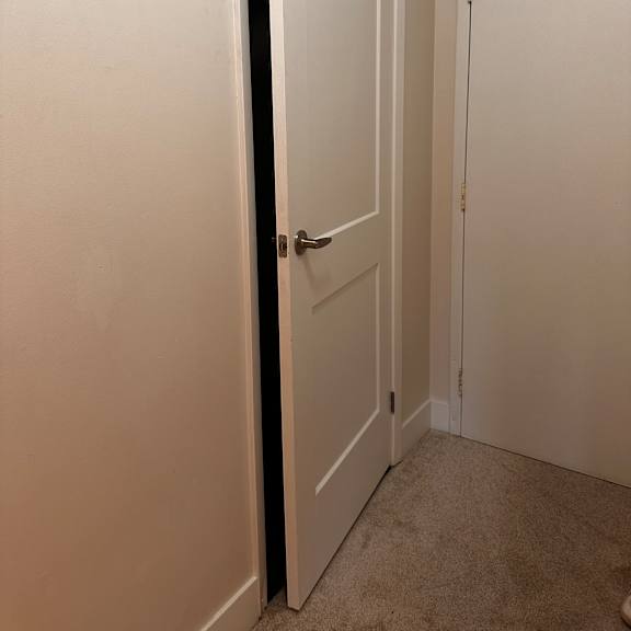 a white cabinet with a black handle and a white drawer with a silver handle.