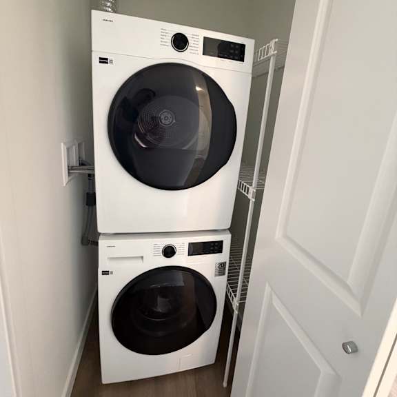 two white ovens under a cabinet.