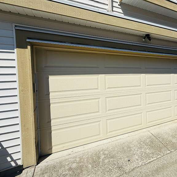 a white garage door is closed and attached to a house.