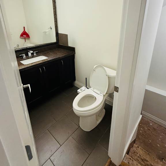 a white toilet in a small bathroom with a mirror above it.