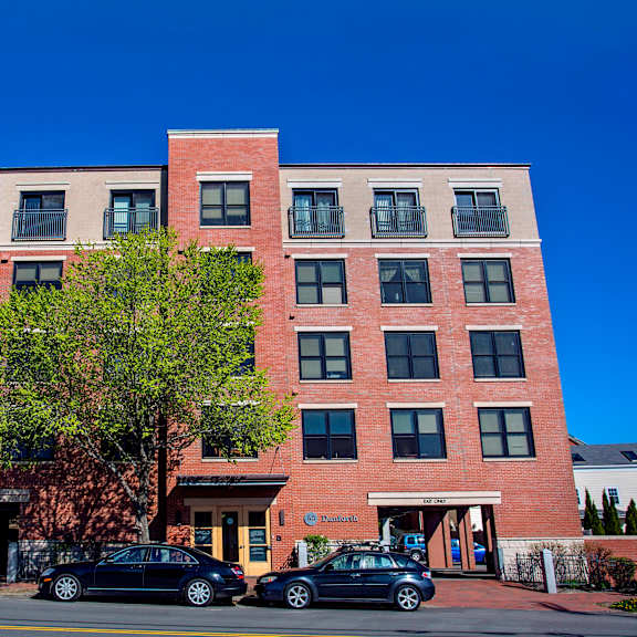a red brick building with a tree in front of it.