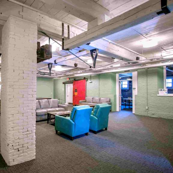 a room with white pillars and a red door.