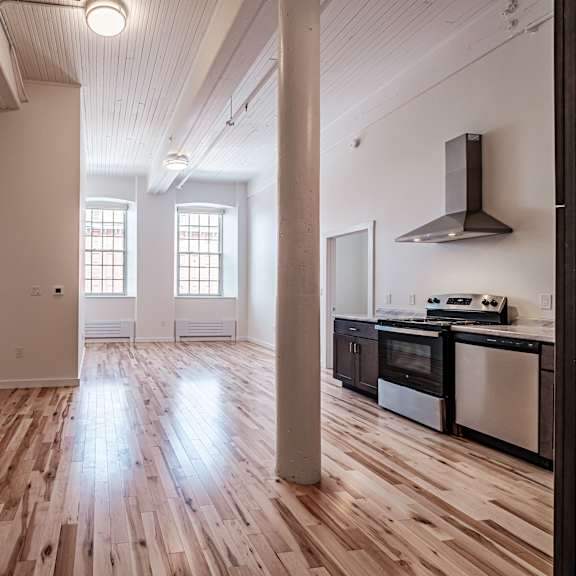 a kitchen with wooden floors and a stove top oven.