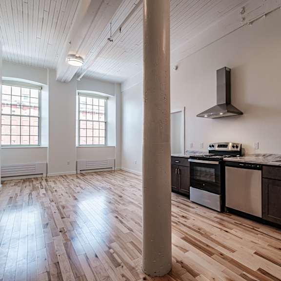 a kitchen with wooden floors and a stainless steel oven.