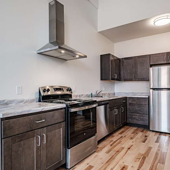 a kitchen with wooden floors and stainless steel appliances.