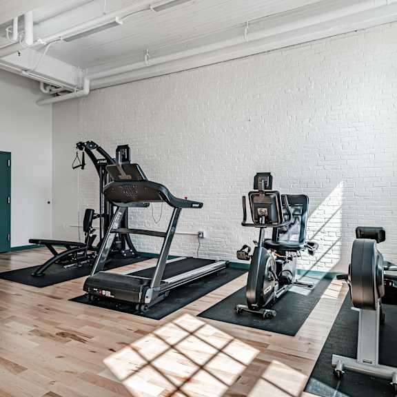 a gym with a treadmill and a stationary bike.