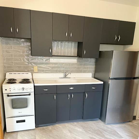 updated kitchen with new flooring and tiled backsplash.