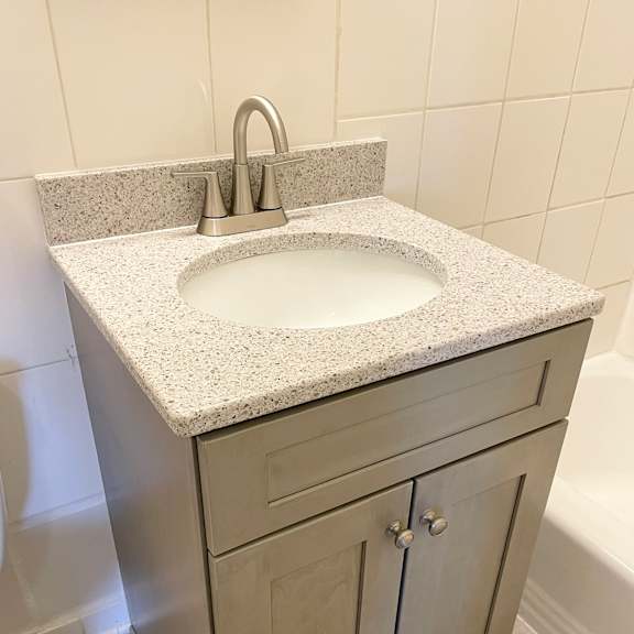 a bathroom sink with a granite countertop and a silver faucet.