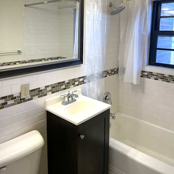 updated bathroom with ceramic tiled shower, walls and floor.
