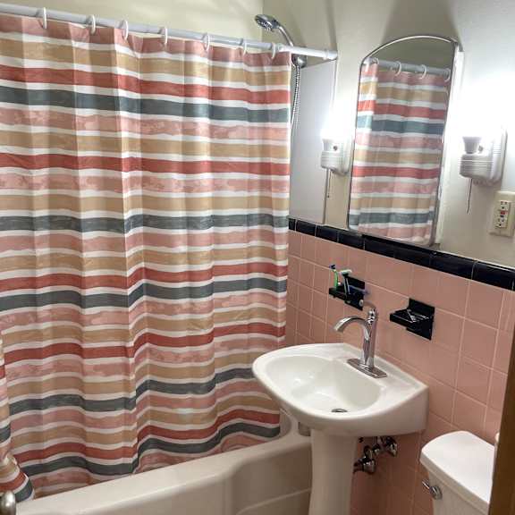 a bathroom with a striped shower curtain and a white sink.