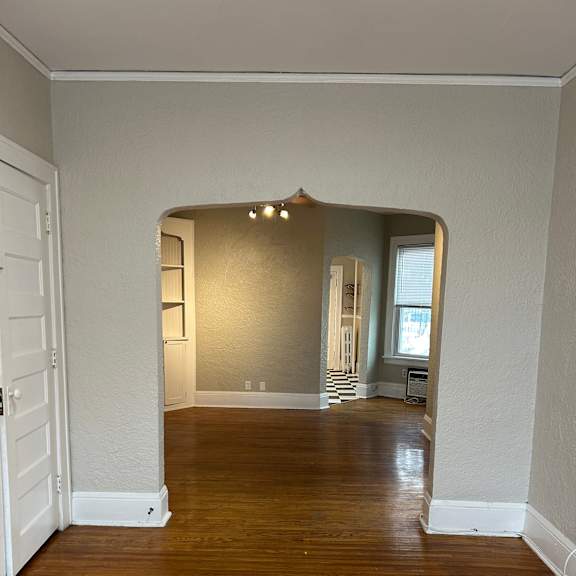 a room with wooden floors and white walls.
