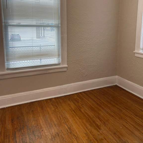 a room with a window and wooden flooring.