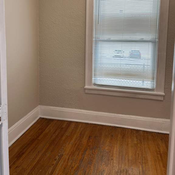 a room with a window and wooden floors.