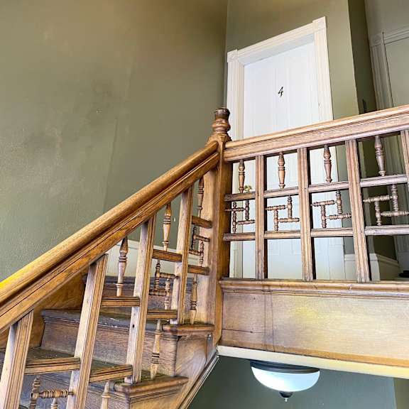 a wooden staircase with a light on the side.