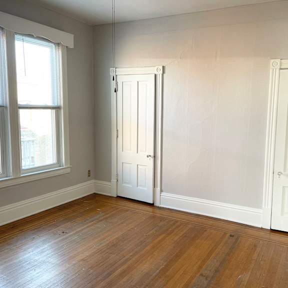 a room with two white doors and a window.