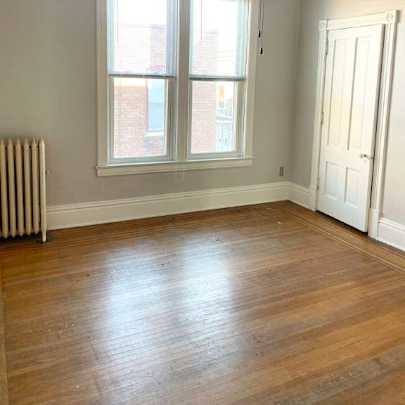 a room with a ceiling fan and a window with blinds.