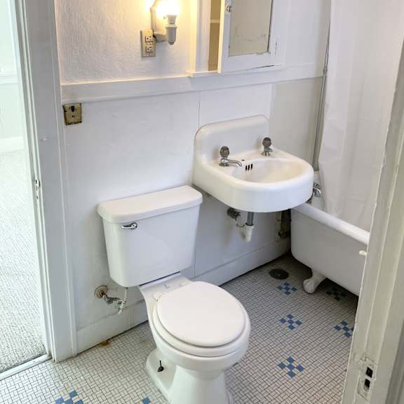 a white toilet sits next to a white sink in a small bathroom.